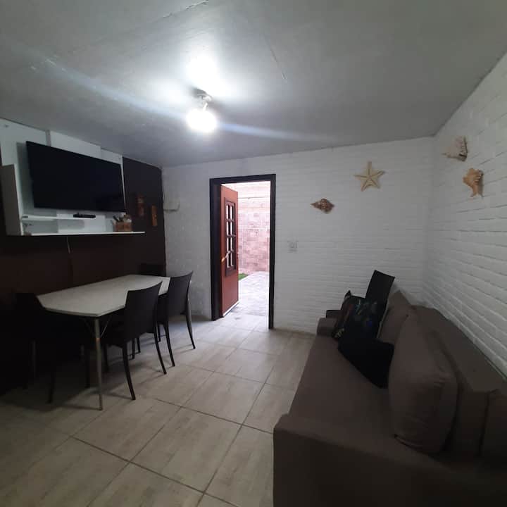 Vista de la sala de estar con la puerta privada del patio trasero abierta.
salón y comedor integrados. El sofá de dos plazas es un sofá cama y está cubierto con una tela Aqua Block.