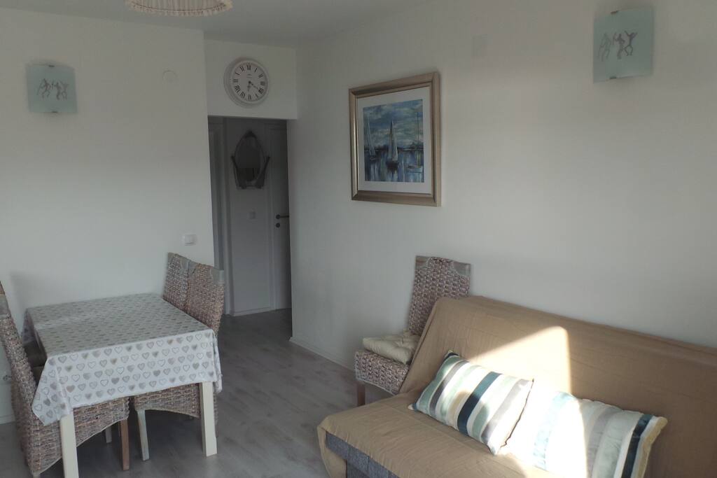 Dining table inside and patio furniture on balcony