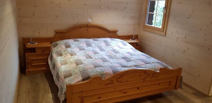 fungua sebule yenye kitanda cha watu wawili, kinachoangalia milima