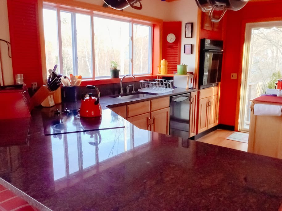 Fully stocked, open-concept kitchen with granite island opens onto side deck facing Acadia.