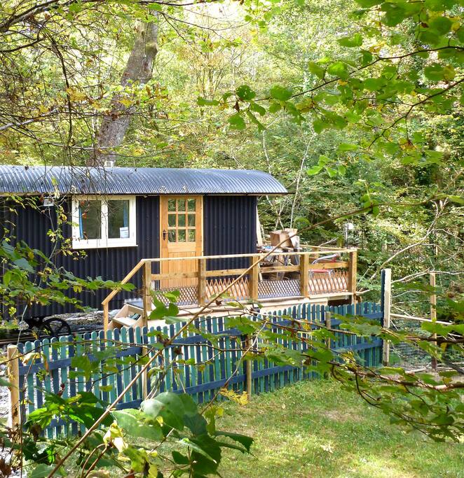 Hut entrance showing veranda and fence round enclosed garden