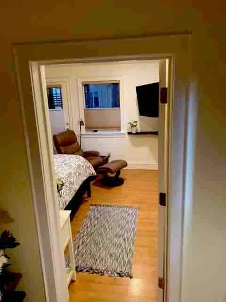 主臥室從客廳有一扇隱私門和一扇通往私人露臺休息區的門。 大屏幕電視、衣櫃和躺椅。 