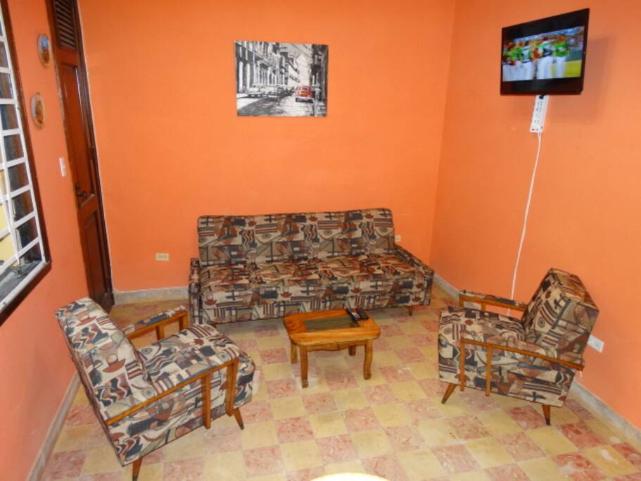 Salón con sofácama y TV de 32 pulgadas.