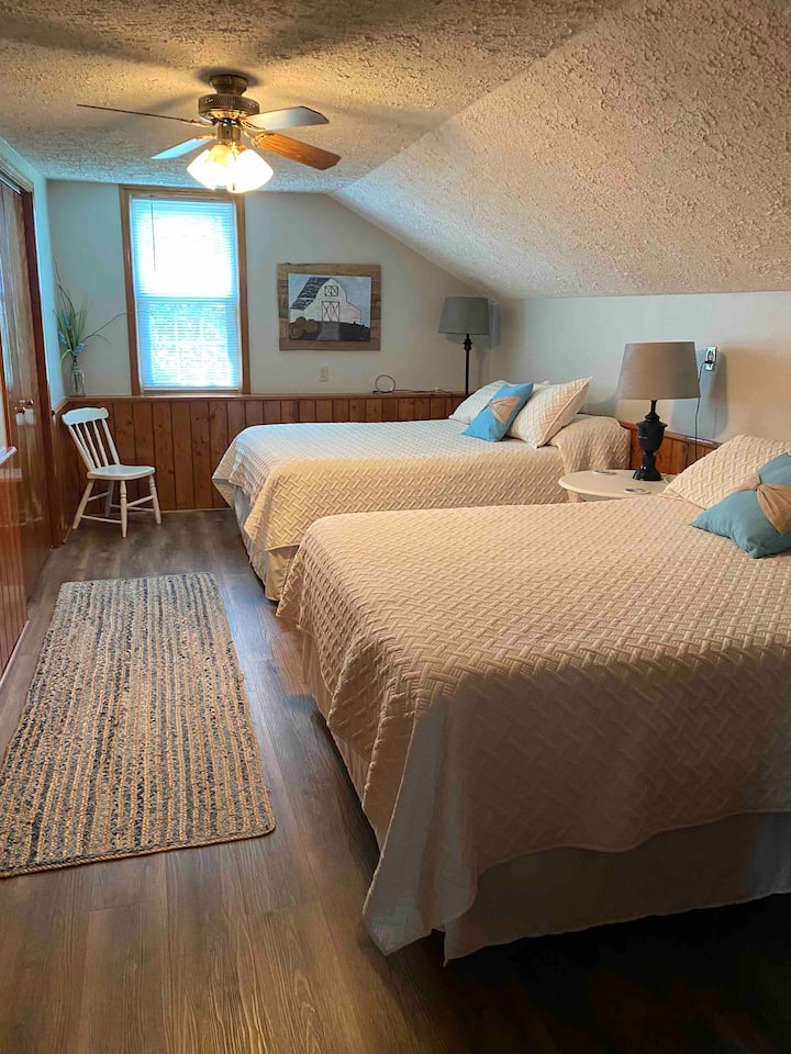 Надворешна спална соба со 2 кревета.  Две прошетки во плакари, а едната е поставена како детска соба за играње.