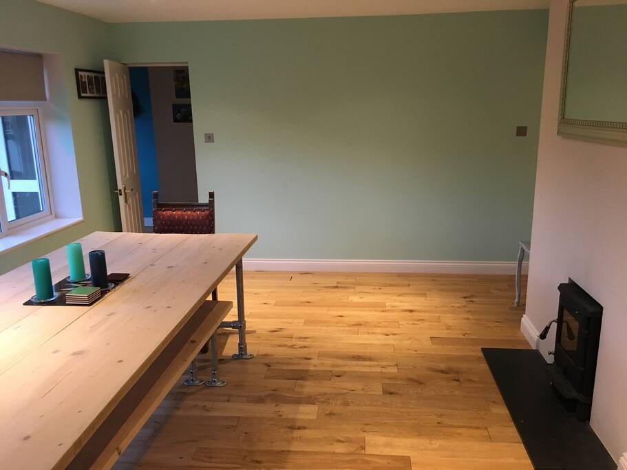 Dining room. Long table with 3 benches. Wood burner.