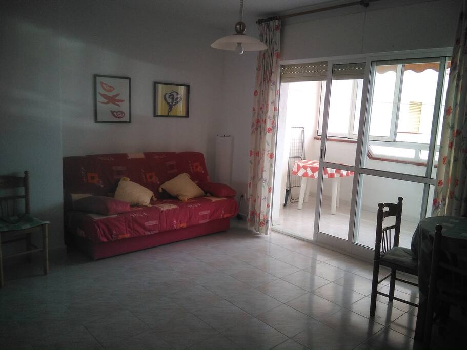 salón con sofá cama y balcón