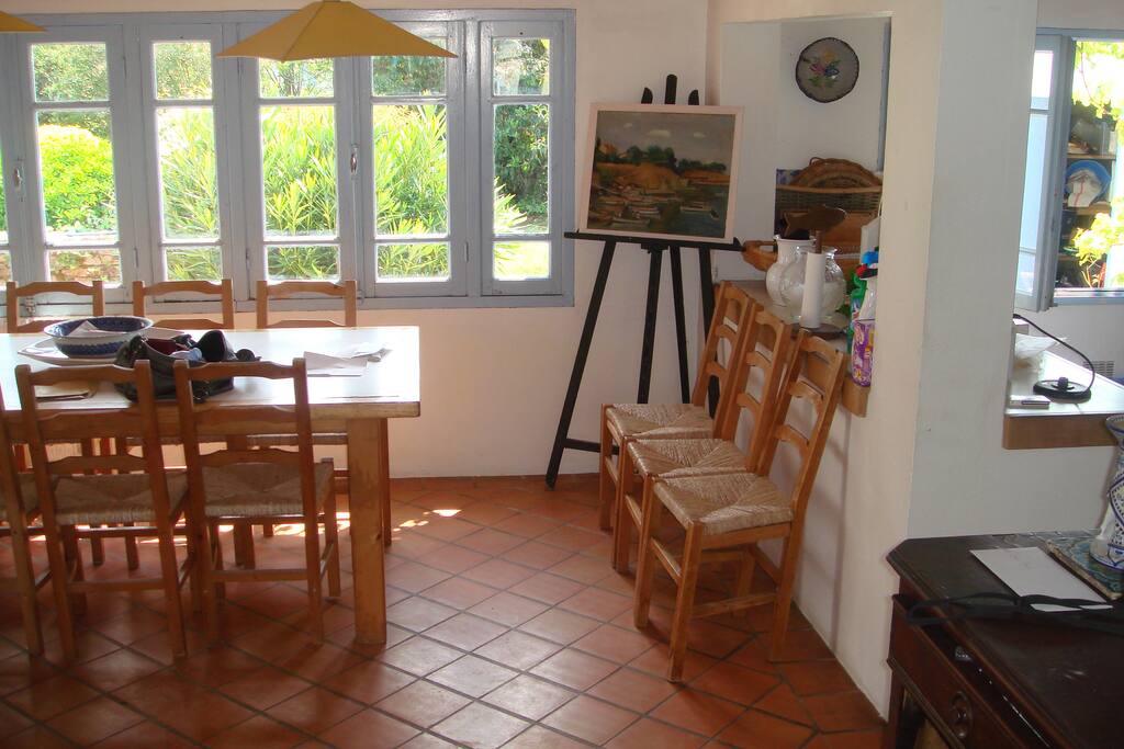 Salle à manger, vue sur le jardin. Cuisine ouverte sur la droite