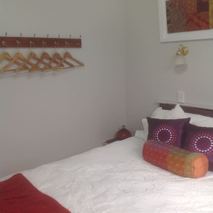 No robe, but hanging space and shelves, plus two bedside tables.