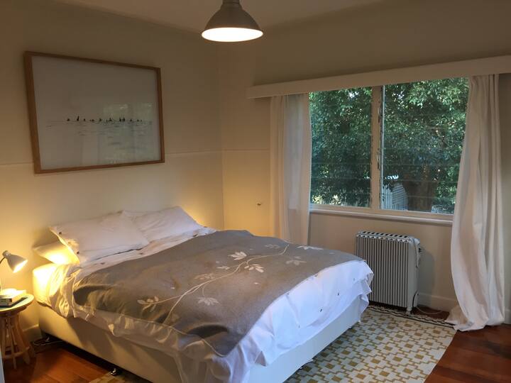 Dormitorio queen más grande con puertas francesas a la terraza trasera