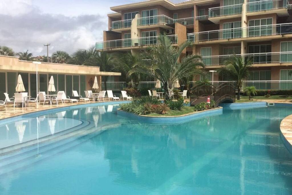 Piscina e ao lado as mesas.