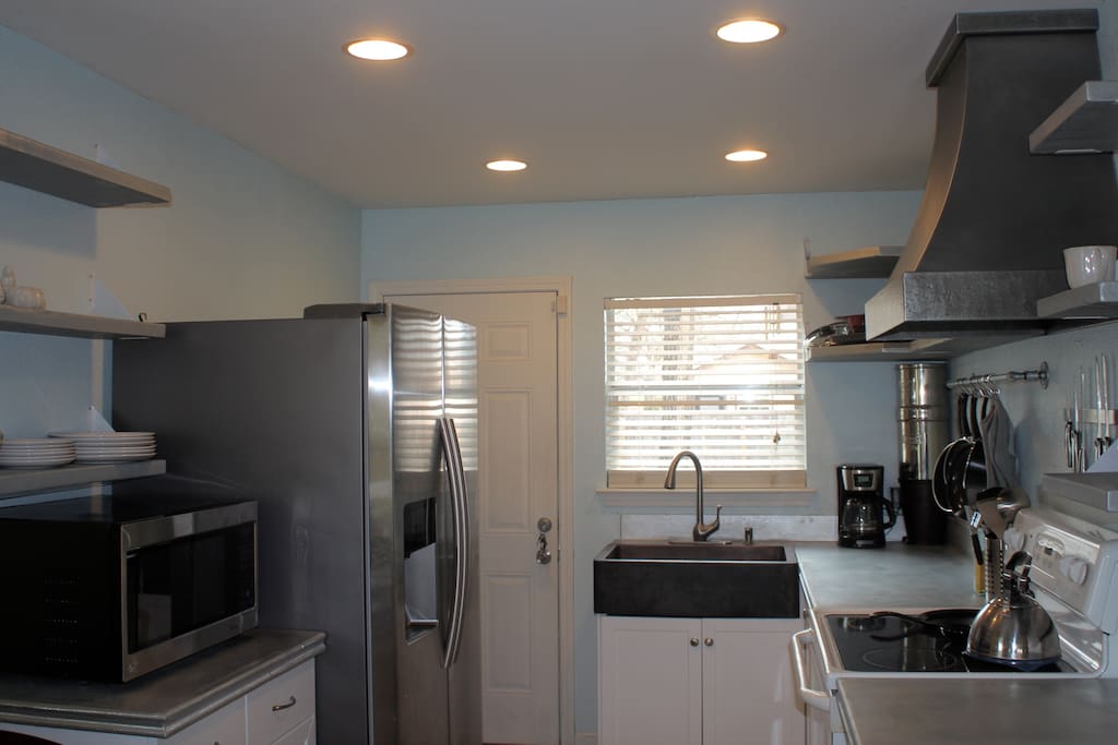 Newly remodeled kitchen. Fully equipped. We have pots and pans, an oven, microwave, large refridgerator, custom metal vent hood, zinc countertops and matching shelving.