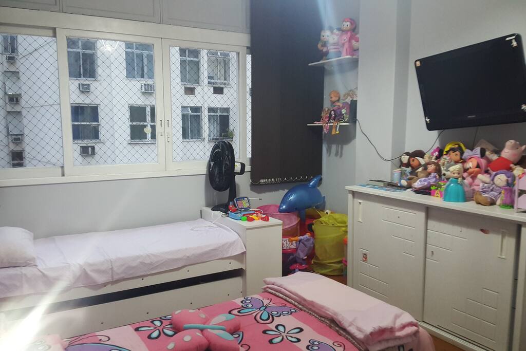 Quarto com duas bicamas, ventilador e tv