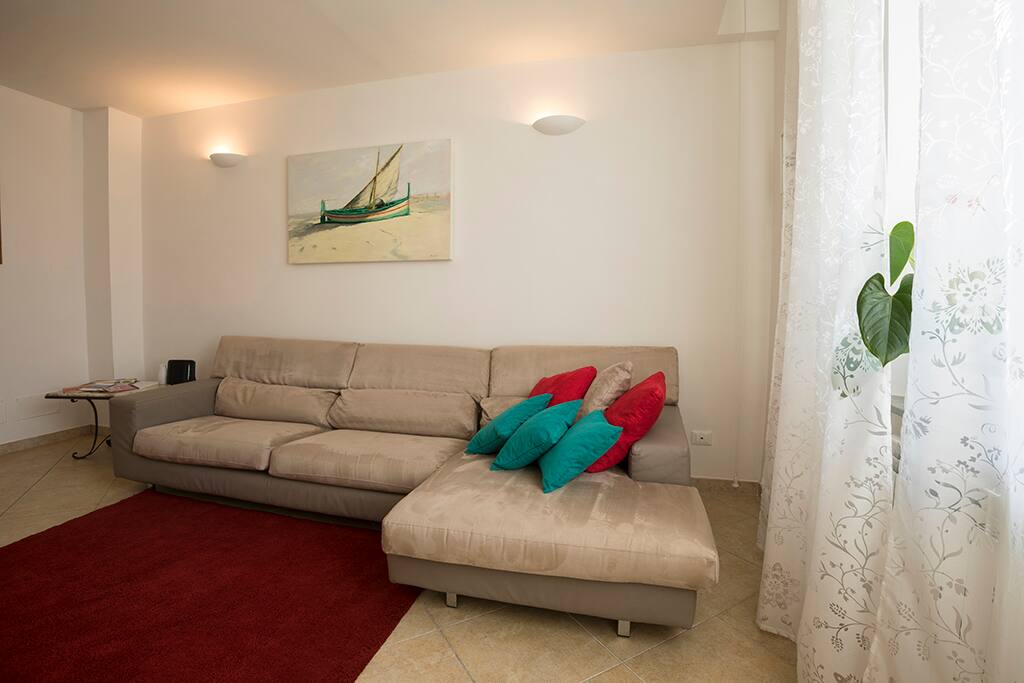 Un ampio e luminoso salotto con una scala per accedere alla zona notte/ ample and bright living room with a comfortable staircase to access the night zone