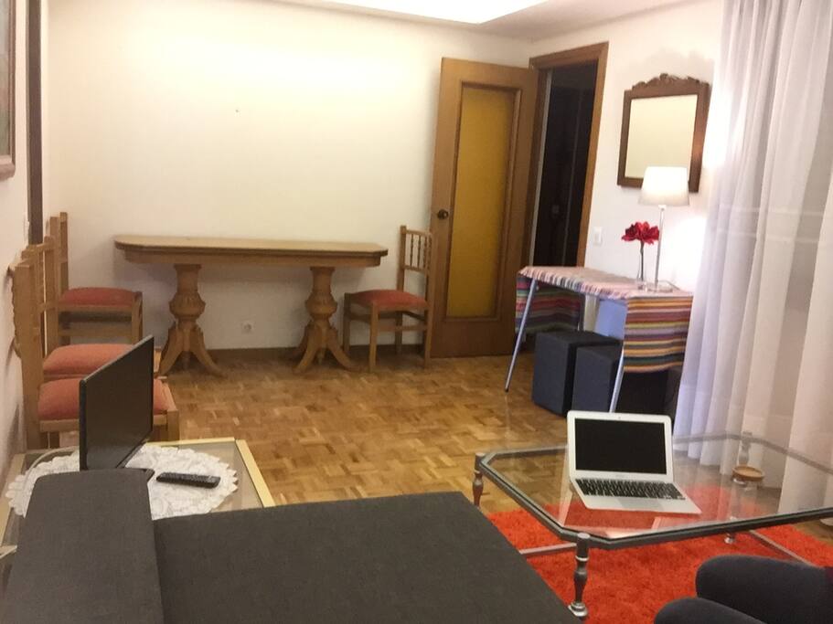 View of the dining table and tv from the couch. The dining table folds out and can seat 6