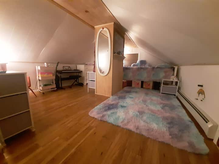 Დაბალი ჭერის სხვენის საძინებელი სრული ზომის საწოლით.