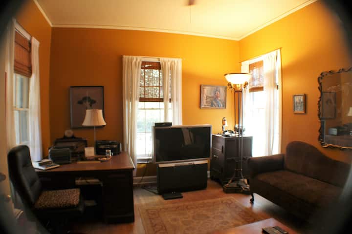 مكتبة وغرفة نوم خامسة مع تلفزيون قديم واسع ومكتب كلاسيكي