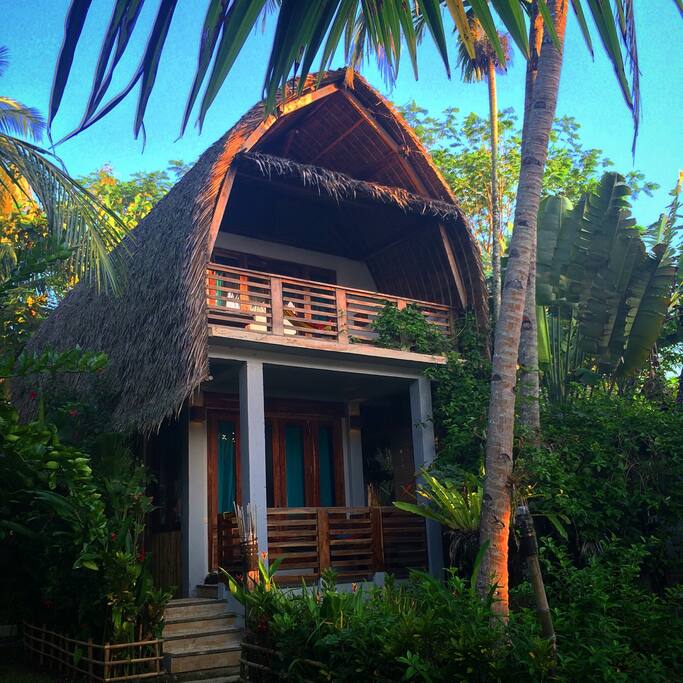 OCEAN VIEW ROOM (upstairs~above the Seaweed Room ~Ideal for 3 persons) •Bedroom 5x5m2 •1 queen size bed with mosquito net •1 single bed with mosquito net •Balcony 2x5m2, 2 daybeds, a hammock and the beautiful view to the beach •Bathroom 2x3m2, western standard toilet, hot and cold shower, sink and mirror •Fan •In-room safety box •Writing desk •TV local channels •Breakfast for 3 persons