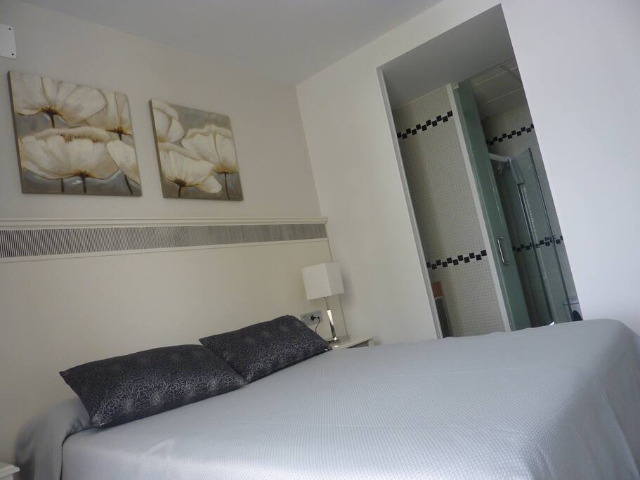 Une chambre parentale lit King Size donnant sur la salle d'eau privative d'un côté, et la balcon de l'autre