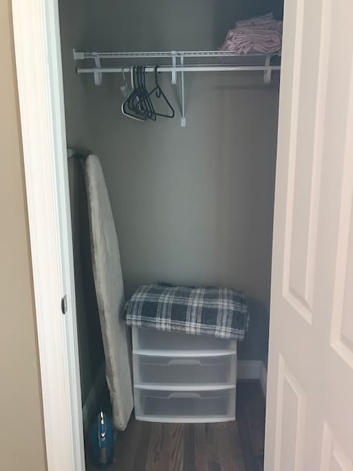 Spacious closet with extras linens, drawers, ad ironing board and iron.