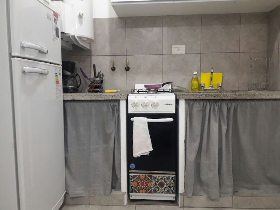 Cocina con horno, vajilla y heladera con frezzer