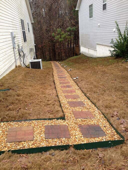 Walkway to the rear of the home for private entry into apartment. Motion sensor lights on the side of the home and back area help to keep the area well lit at night.