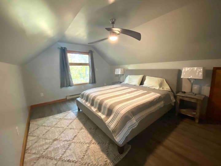 Chumba kipana cha kulala cha ghorofa ya pili chenye kitanda aina ya king na joto la umeme. Hakuna AC, lakini feni ya dari inafanya hewa iendelee kusonga. Bafu kamili la beseni/la bomba pia liko kwenye ghorofa hii.