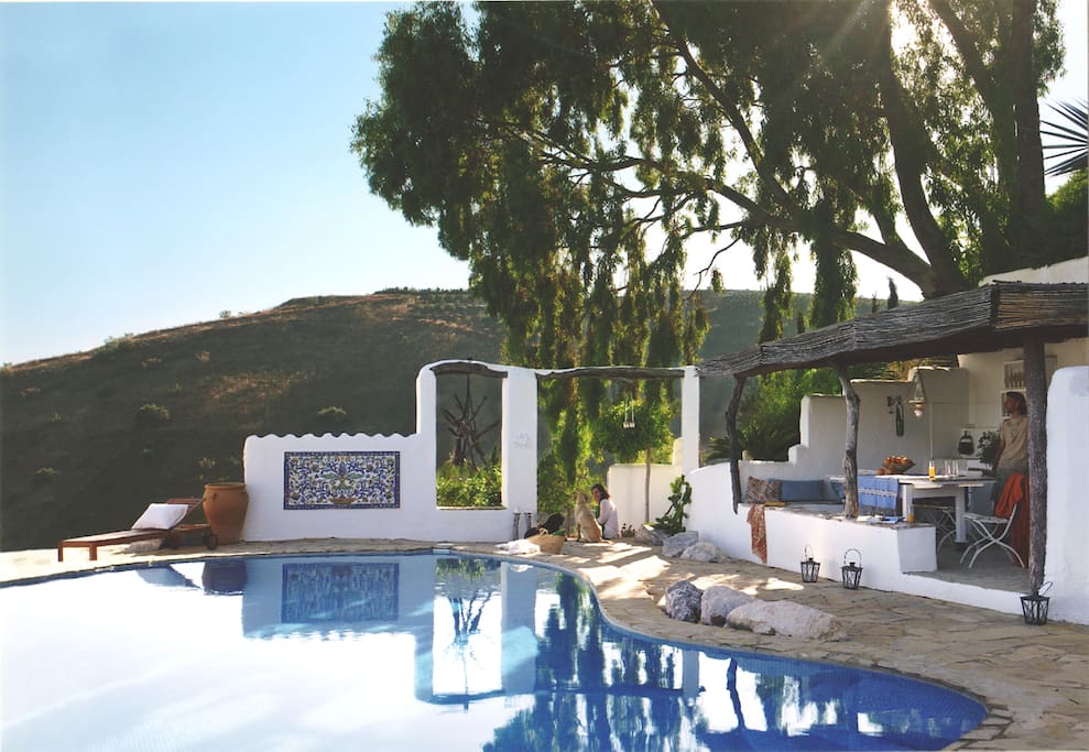 The private pool features a covered summer kitchen with barbecue and dining area, refrigerator and lounge areas.