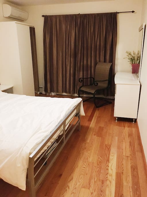 A bedroom has a dresser, a chair, a closet and an walk-in closet on the other side.