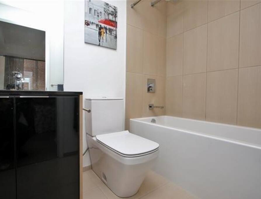 Clean modern bathroom. Deep tub, great to soak away the long day in city.