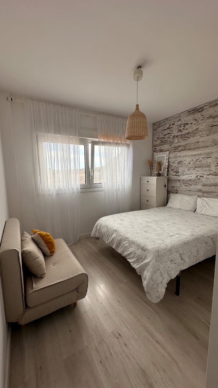 Quarto principal, com banheiro privativo com banheira e sofá-cama.