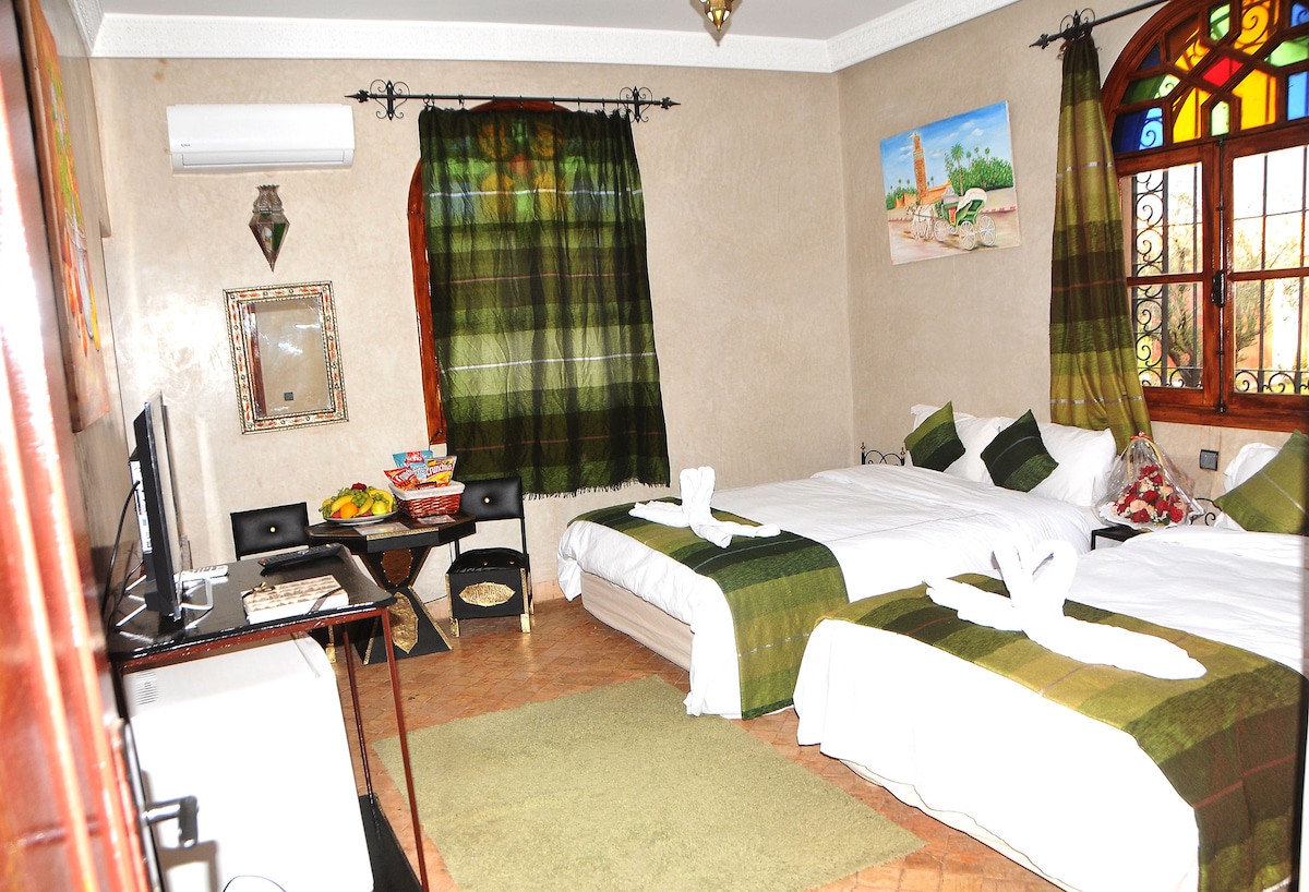 三人房，配有独立浴室、电视和起居区 