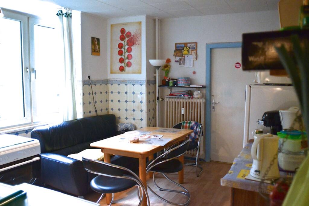 Küche mit Waschmachine, Herd, Kühlschrank und Mikrowelle