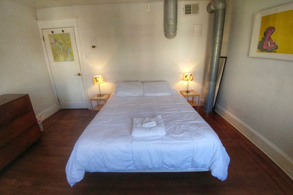 This comfy queen sized bed is wrapped in luxury sheets.
