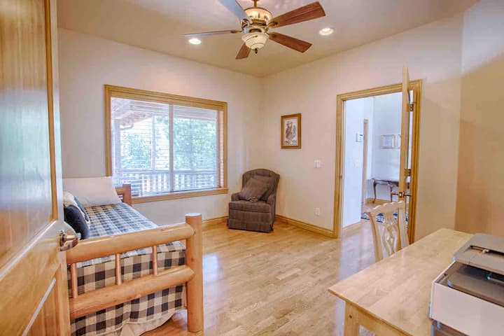 Estudio/dormitorio en el piso principal con un sofá cama y una estación de trabajo.