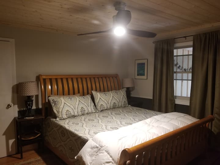 1-ლი სართულის საძინებელი - საწოლი დიდი ხნით. Მხატვრული სარკის მქონე უჯრის გულმკერდი ამ ფოტოზე ჩანს მარცხნივ. Კარადა გვერდითა მაგიდის მარცხნივ მდებარეობს.