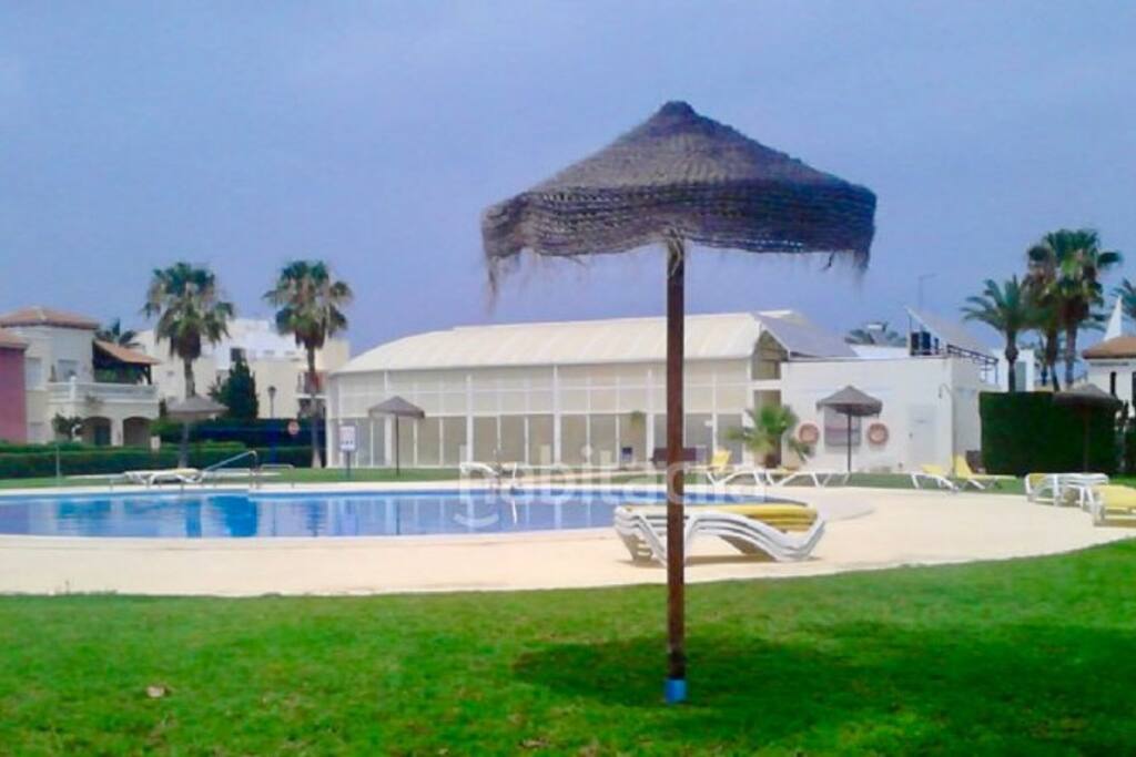 Piscina abierta con la piscina cubierta al fondo