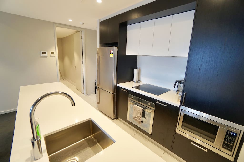 The kitchen and dining area which contains high quality non stick pots and pans, first aid kit, fridge, oven, microwave, coffee and tea, nutri bullet, rice cooker, toaster and a 6 seater dining table!