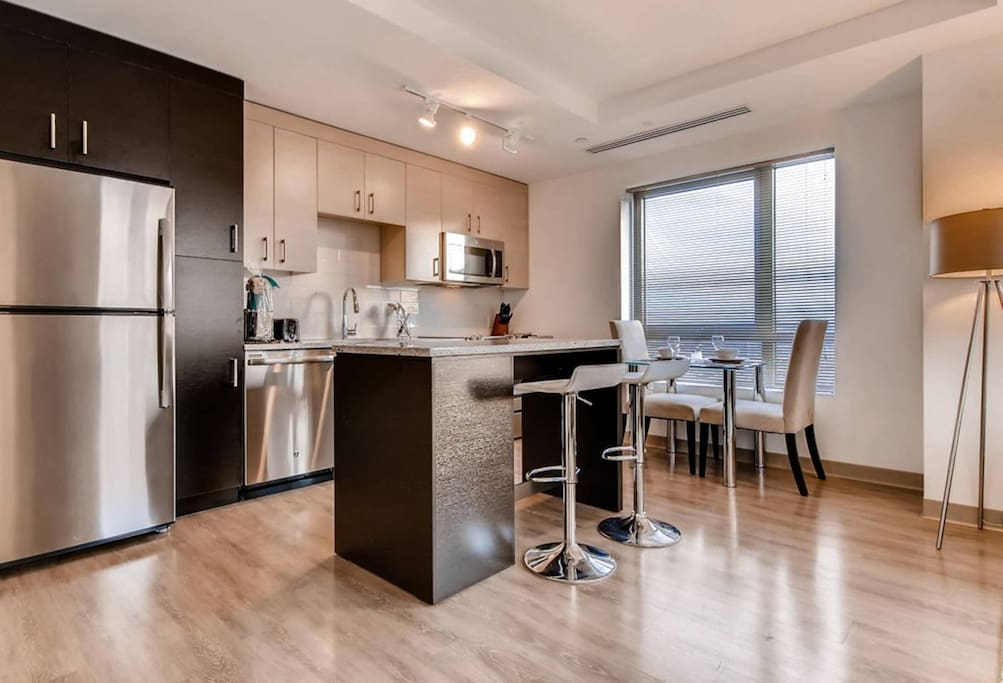 Fully equipped kitchen with stainless steel appliances, pots, pans and dishes