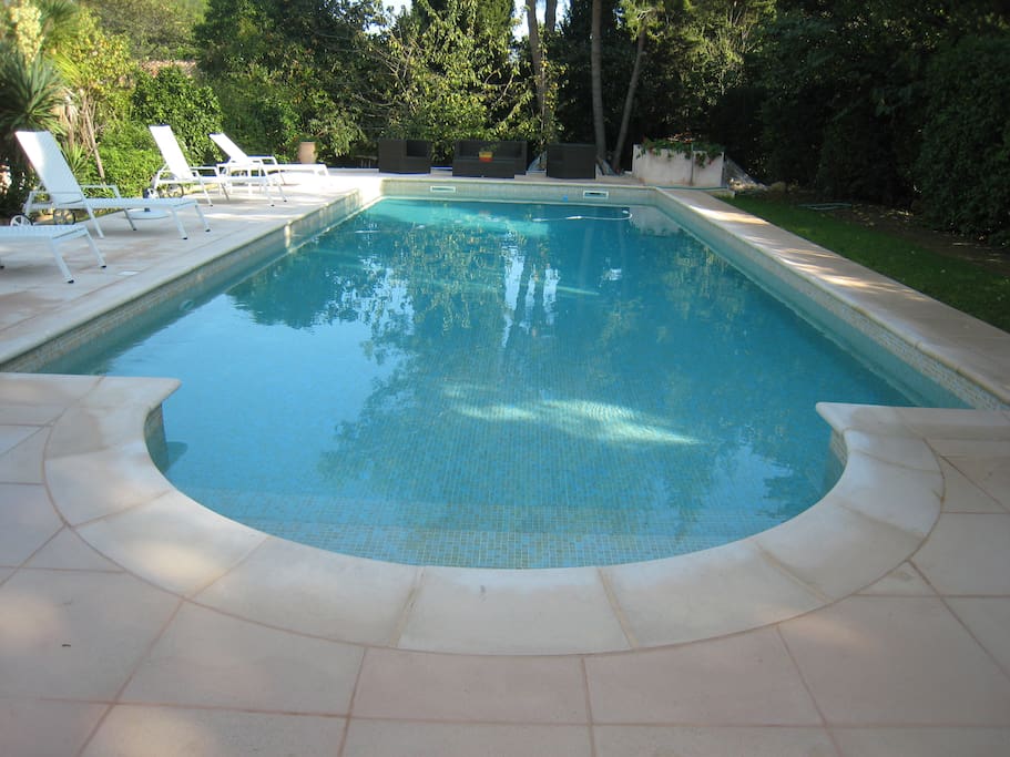 Grande piscine, transats, salon de jardin, parasol.