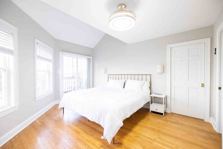 Dormitorio en el tercer piso con cama tamaño queen, baño privado con bañera de hidromasaje y acceso directo al balcón del tercer nivel