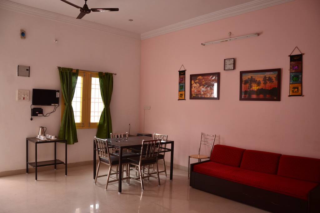 Living room consists of a dining table, a sofa, 2 fans and a wardrobe
