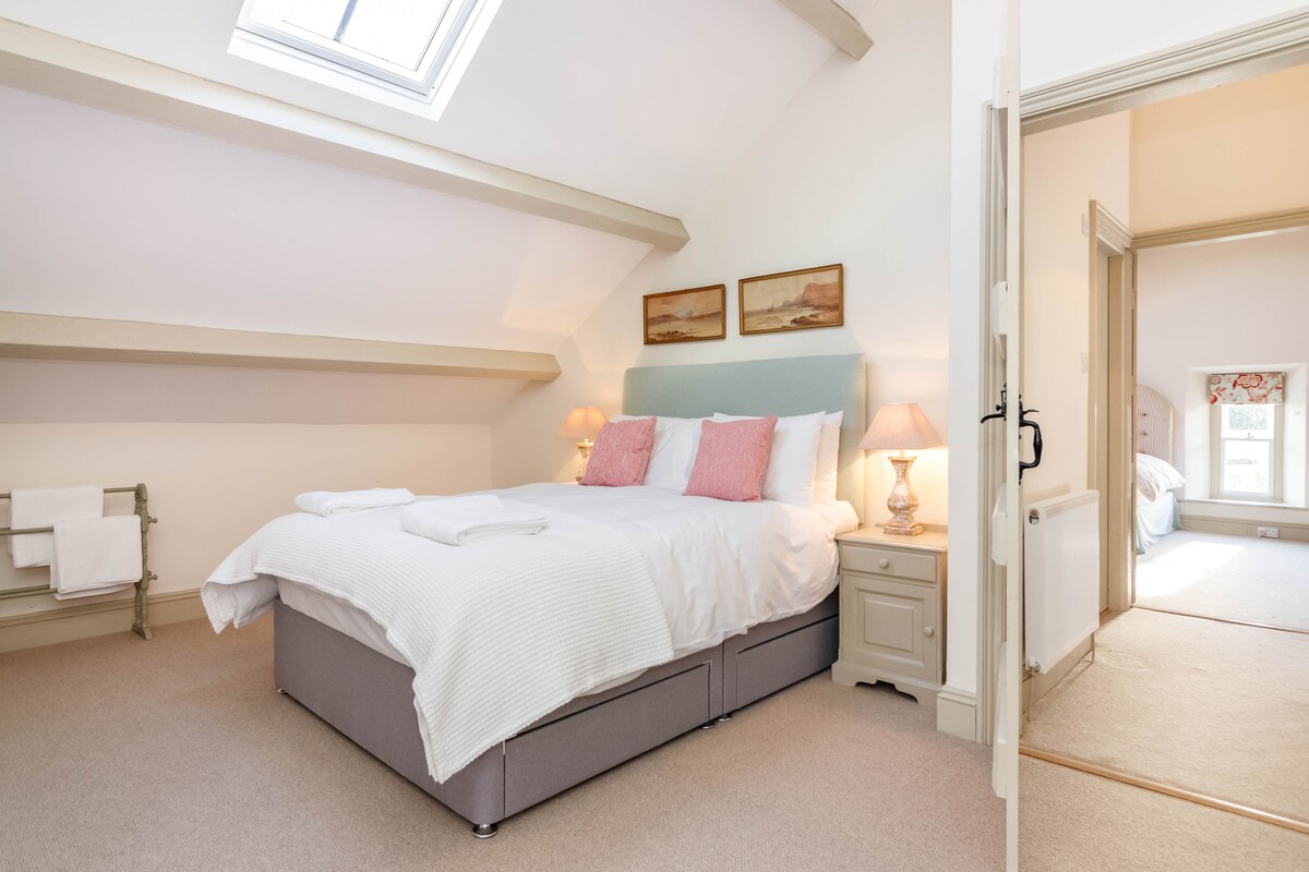 חדר השינה הגדול והמואר בקומה השנייה עם שפע של מקום לתלות בגדים.