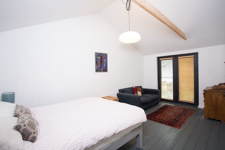 تطل غرفة النوم الرئيسية الكبيرة على الحديقة