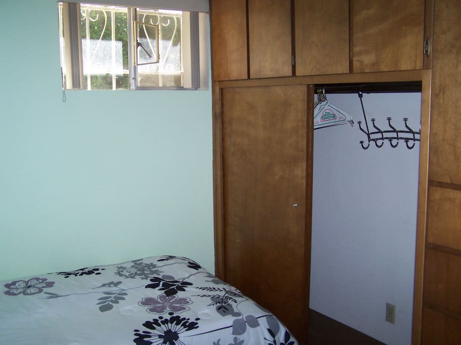 Large built-in closet with drawers, cabinets and a few hooks and hangers.