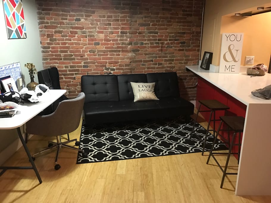 Black futon bed in cozy office area.