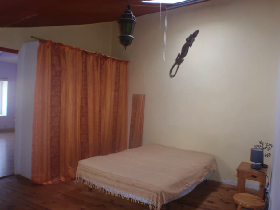 La première chambre avec un lit 2 places, grand placard, table de chevet et velux.