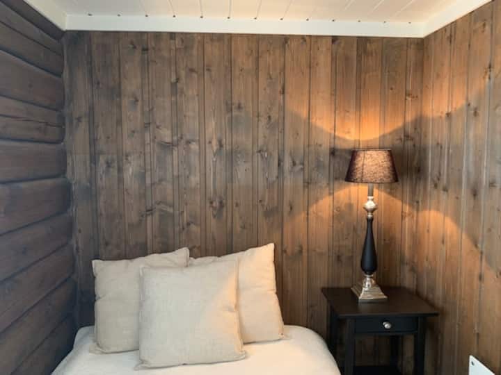 Acogedor dormitorio con troncos loft y cama doble normal de 120x200 cm.