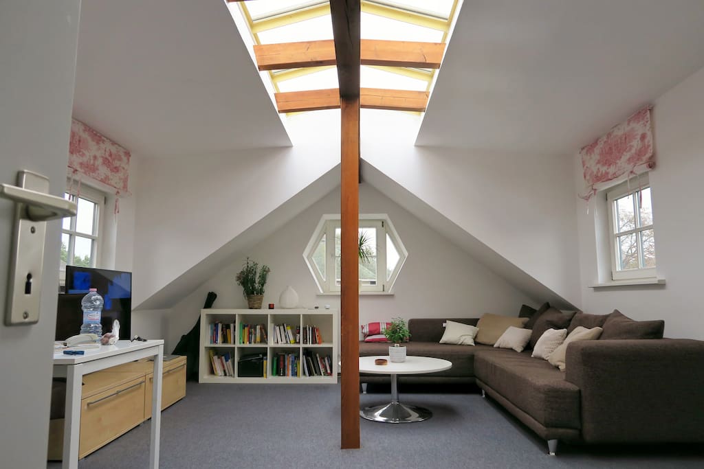 Sehr helles Wohnzimmer mit Dachgiebelfenster, mit Schlafsofa, 4k TV, Esstisch und