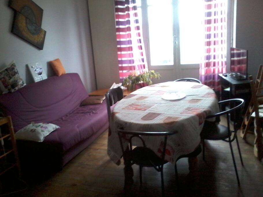 Salon aux couleurs pastels et fraîches, exposé plein sud avec canapé lit.