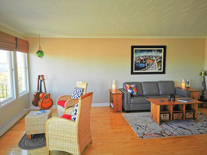 Sebule iliyo na vifaa vya muziki, michezo, vitabu, na taa za kupendeza zenye mandhari ya bahari. 